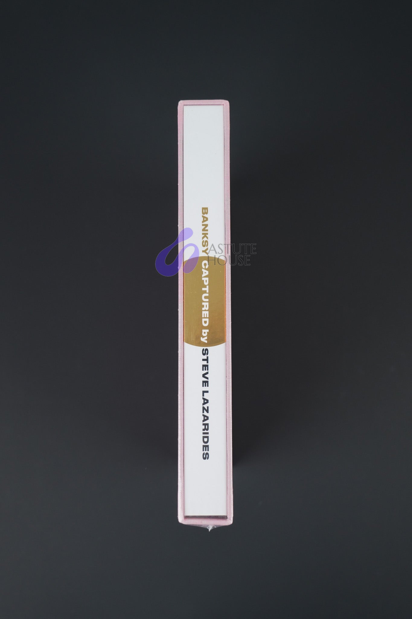 Close-up of the spine on Banksy Captured Volume 2, showcasing its elegant gold foil and slipcase texture.